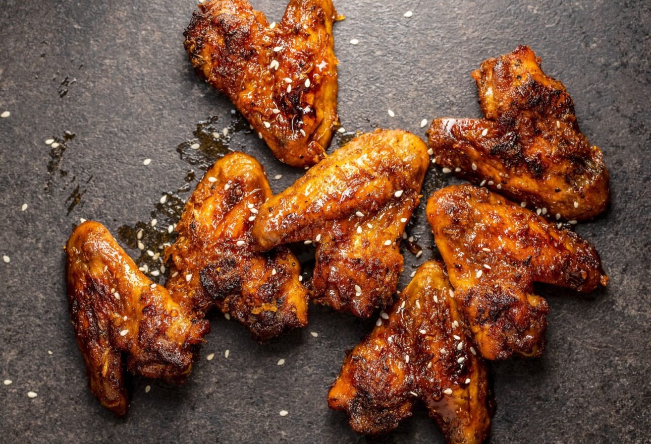 Crispy reheated chicken wings on a plate showing golden skin with steaming hot texture.